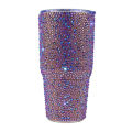 Rhinestone-encrusted double-walled stainless steel tumbler with a clear straw featuring a shimmering iridescent finish.