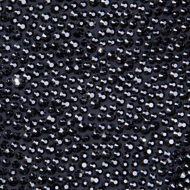 Black blazer covered in shimmering black rhinestones featuring a satin black lapel and two buttons on the front. Black blazer covered in shimmering black rhinestones featuring a satin black lapel and two buttons on the front.