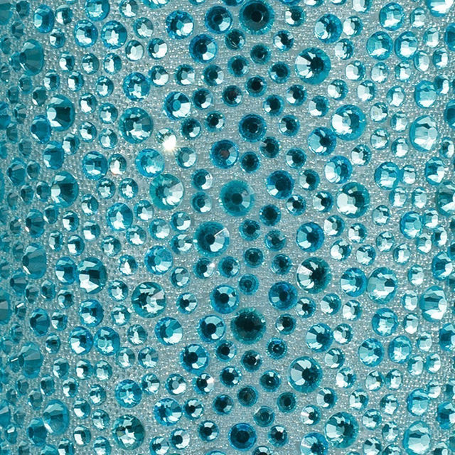 A tube of clear adhesive beside a clear pouch filled with silver and iridescent rhinestones of various sizes and shapes. A tube of clear adhesive beside a clear pouch filled with silver and iridescent rhinestones of various sizes and shapes.
